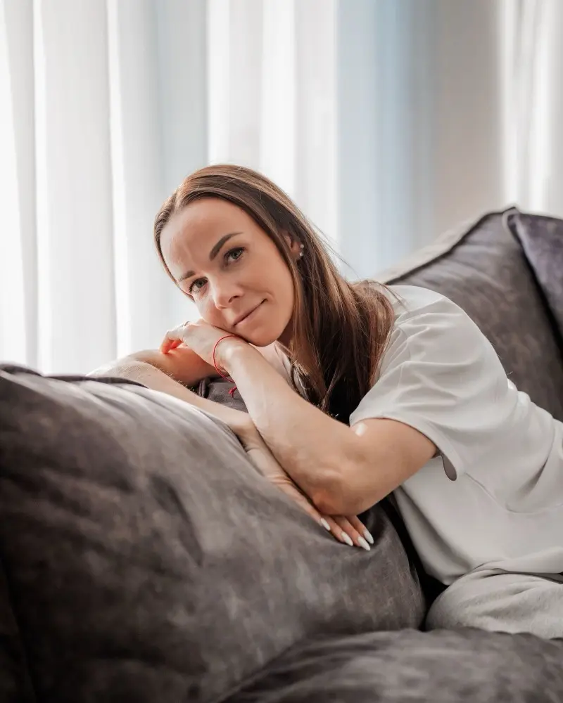 Karmen Kiier diivanil, toetab pea käte peale